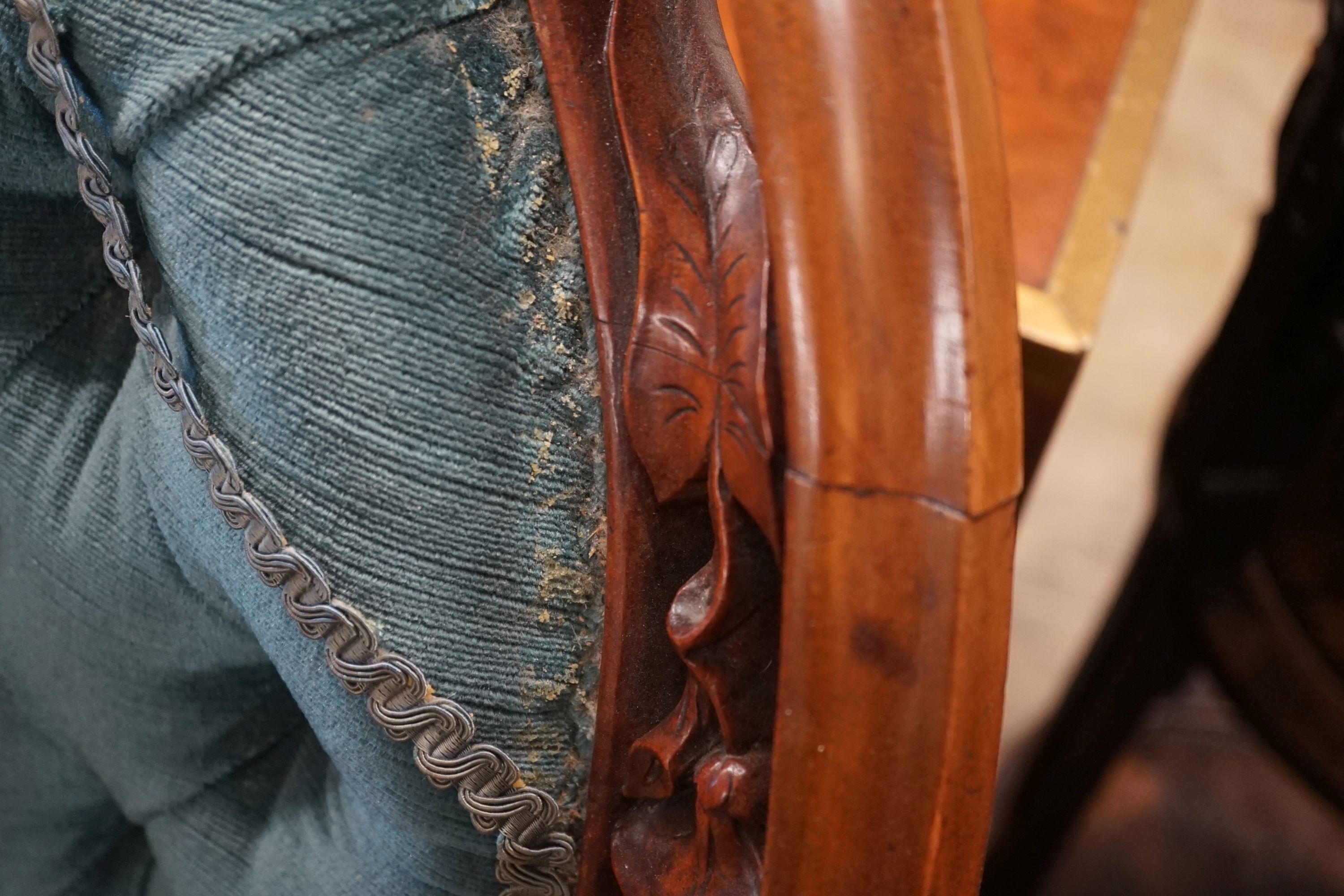 A Victorian carved mahogany spoon back salon chair with buttoned blue upholstery